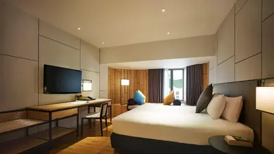 a hotel room with a bed and a desk at PARKROYAL Penang Resort in Batu Ferringhi