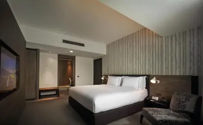 a hotel room with a bed and a chair at G Hotel Gurney in George Town