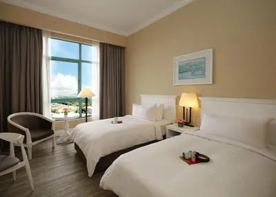 a hotel room with two beds and a window at Berjaya Penang Hotel in George Town