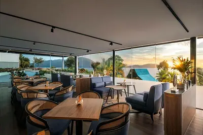 a restaurant with tables and chairs and large windows at DoubleTree by Hilton Damai Laut in Lumut