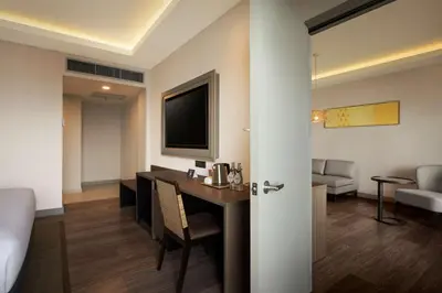a room with a desk and a tv and a living room at DoubleTree by Hilton Damai Laut in Lumut
