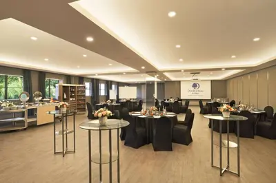 a restaurant with black chairs and tables with flowers on them at DoubleTree by Hilton Damai Laut in Lumut