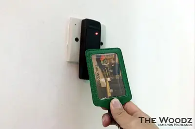 a person holding a video game in front of a wall at The Woodz Homestay - 3 Bedroom in Cameron Highlands