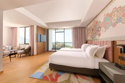 a bedroom with a large bed and a living room at M Social Resort Penang in George Town