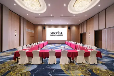 a conference room with tables and chairs and a screen at M Social Resort Penang in George Town