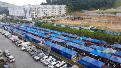 an aerial view of a parking lot with blue umbrellas at NAZMI & LINDA CAMERON HOMESTAY in Cameron Highlands