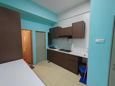 a small kitchen with brown cabinets and blue walls at NAZMI & LINDA CAMERON HOMESTAY in Cameron Highlands