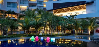 a hotel courtyard with a swimming pool and palm trees at DoubleTree Resort by Hilton Hotel Penang in Batu Ferringhi