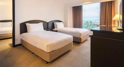 a hotel room with two beds and a window at Bayview Hotel Georgetown Penang in George Town