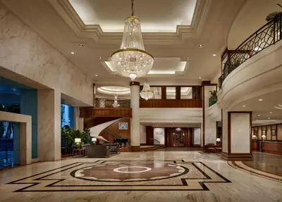 a lobby of a hotel with a chandelier at Gurney Bay Hotel, A PARKROYAL Partner Hotel in George Town