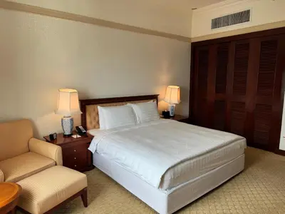 a bedroom with a large white bed and a chair at Gurney Bay Hotel, A PARKROYAL Partner Hotel in George Town