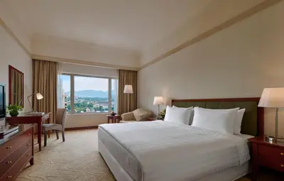 a hotel room with a bed and a large window at Gurney Bay Hotel, A PARKROYAL Partner Hotel in George Town