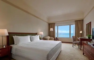 a hotel room with a bed and a large window at Gurney Bay Hotel, A PARKROYAL Partner Hotel in George Town