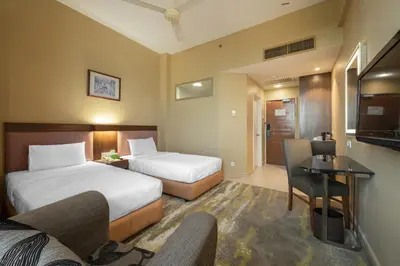 a hotel room with two beds and a television at Cititel Penang in George Town