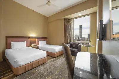 a hotel room with two beds and a table at Cititel Penang in George Town