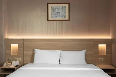 a bedroom with a bed with two lamps and a phone at Cititel Penang in George Town