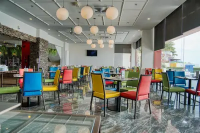 a dining room with colorful chairs and tables at Hotel Sentral Seaview @ ​Beachfront in George Town