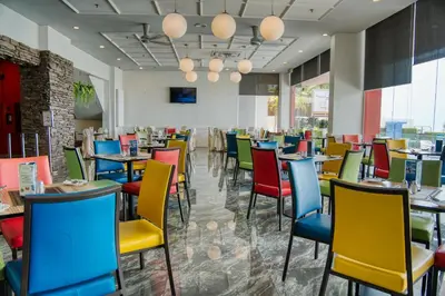 a dining room with tables and colorful chairs at Hotel Sentral Seaview @ ​Beachfront in George Town