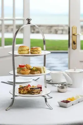 a three tiered tray of food on a table at Eastern & Oriental Hotel in George Town
