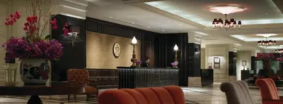 a hotel lobby with a table and chairs at Eastern & Oriental Hotel in George Town