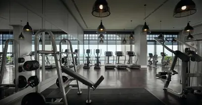 a gym with rows of exercise equipment in a room at Eastern & Oriental Hotel in George Town
