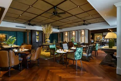a restaurant with tables and chairs in a room at Eastern & Oriental Hotel in George Town