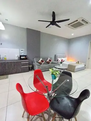 a living room with red chairs and a table at Octagon Premium Ipoh Town Center by Grab A Stay in Ipoh