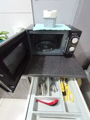 a microwave oven sitting on top of a refrigerator at Octagon Premium Ipoh Town Center by Grab A Stay in Ipoh