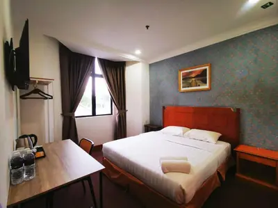 a bedroom with a bed and a desk in it at Regalodge Hotel & Spa Ipoh in Ipoh