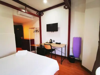 a bedroom with a bed and a desk with a tv at Regalodge Hotel & Spa Ipoh in Ipoh
