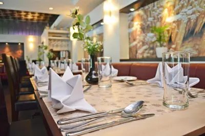 a table in a restaurant with silverware and napkins at Regalodge Hotel & Spa Ipoh in Ipoh