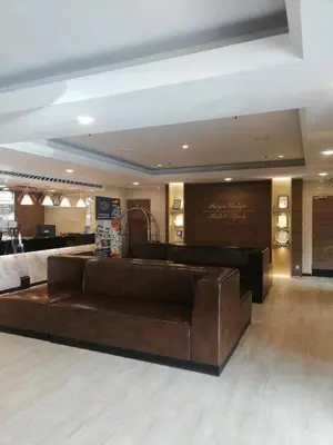 a lobby with a brown leather couch in a room at Regalodge Hotel & Spa Ipoh in Ipoh