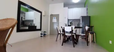a dining room with a table and a green wall at My 2Rooms Apartments @ Golden Hills Pasar Malam in Cameron Highlands