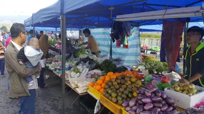 a group of people standing around a market with produce at My 2Rooms Apartments @ Golden Hills Pasar Malam in Cameron Highlands