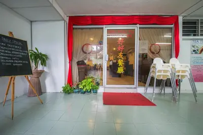 a store front with red curtains and white tables and chairs at YMCA Penang in George Town