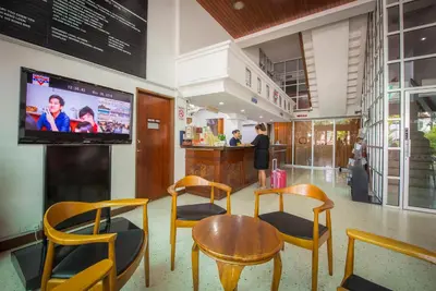 a restaurant with chairs and a table and a tv at YMCA Penang in George Town