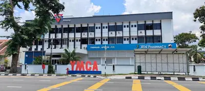 a large white building with a sign in front of it at YMCA Penang in George Town
