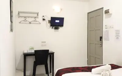 a room with a bed and a desk with a computer at Max Ferringhi Hotel in Batu Ferringhi