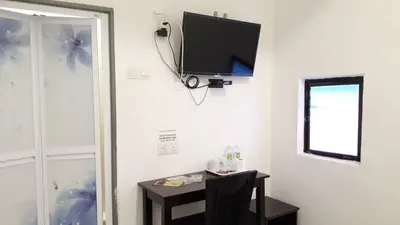 a room with a table and a tv on a wall at Max Ferringhi Hotel in Batu Ferringhi