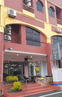 a pink and yellow building with an american flag at Max Ferringhi Hotel in Batu Ferringhi