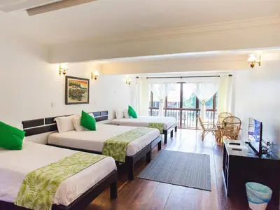 a hotel room with three beds and a balcony at Anjungan Beach Resort in Pangkor