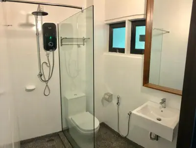 a bathroom with a shower and a toilet and a sink at Anjungan Beach Resort in Pangkor