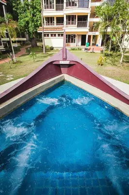 an empty swimming pool in front of a building at Anjungan Beach Resort in Pangkor