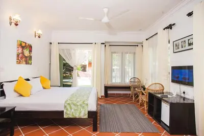 a bedroom with a bed and a desk and a television at Anjungan Beach Resort in Pangkor