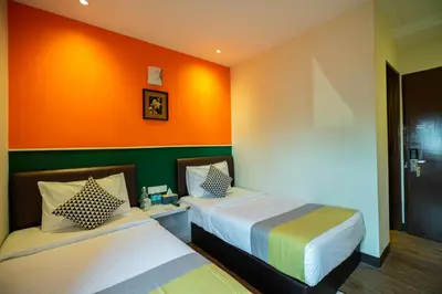 two beds in a room with orange and green at Link Hotel in George Town