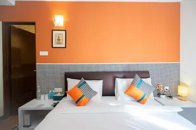 a bedroom with a bed with an orange wall at Link Hotel in George Town