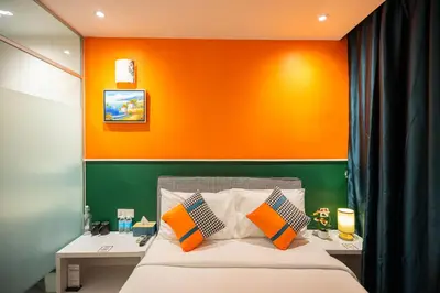 a bedroom with an orange and green wall at Link Hotel in George Town