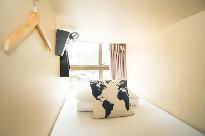 a room with a cow pillow in front of a window at Traveller Bunker Hostel in Cameron Highlands