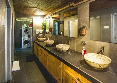 a bathroom with three sinks and a washing machine at Traveller Bunker Hostel in Cameron Highlands