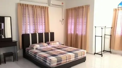 a bedroom with a bed in a room with pink curtains at J&P Homestays House 1 in Kampar